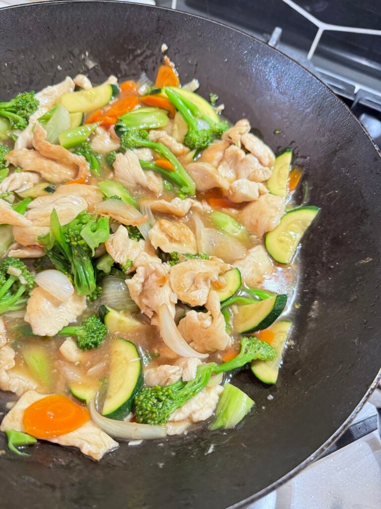 Weeknight chicken stir fry with blanched vegetables in a wok